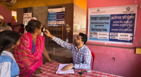 A skin check-up camp at Valkhed, with a queue of patients being seen one after another beneath the camp banner.